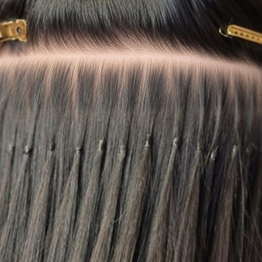 Neat rows of tiny micro European bonds in dark hair